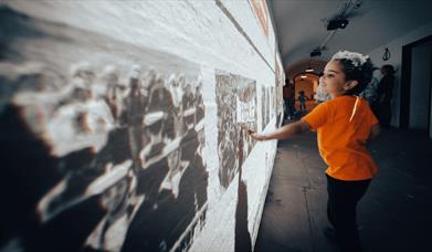 A child looking at former prisoners.