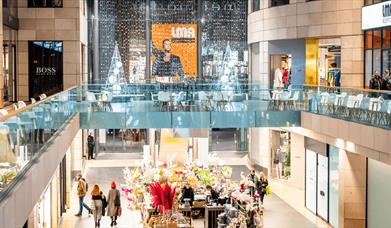 A shopping centre with a large picture of Robbie Williams at the front.