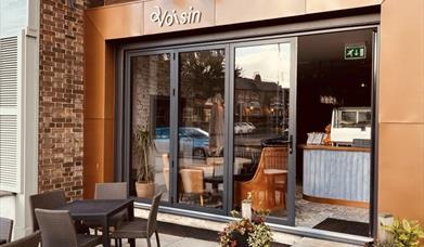 The exterior of Voisin including outdoor seating.