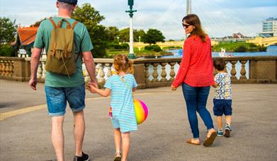 Family of man, woman and two children viewed from behind with a background of Southport Marine Lake