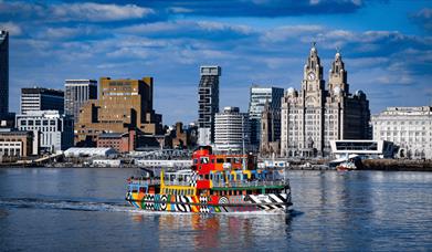 the colourful and patterned Dazzle ferry on the river
